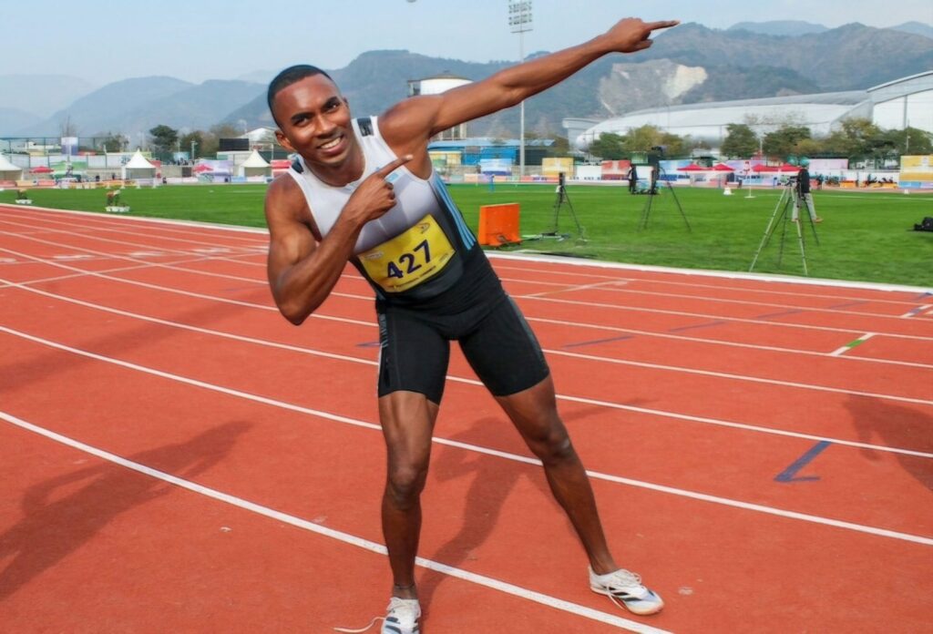 Animesh Kujur with arms raised in celebration after completing a race, showcasing emotion and athletic spirit.