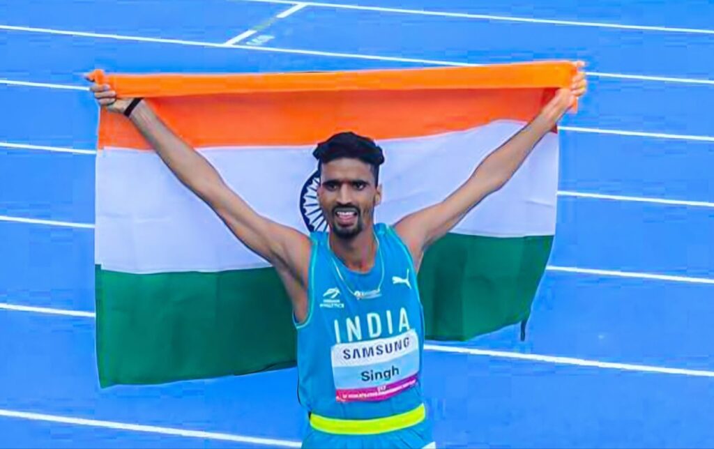 Indian athlete Gulveer Singh running on track during 1500m race at Los Angeles Sunset Tour 2025, wearing blue India jersey.