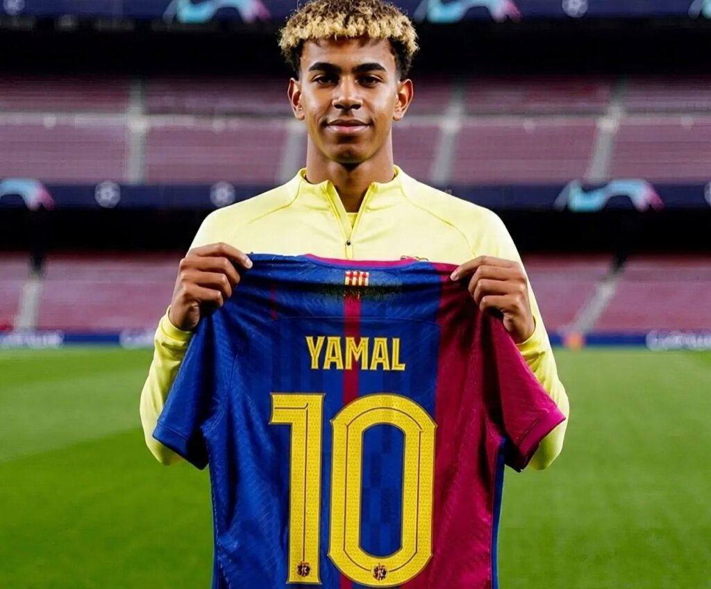 Lamine Yamal holds up the No. 10 Barcelona jersey.