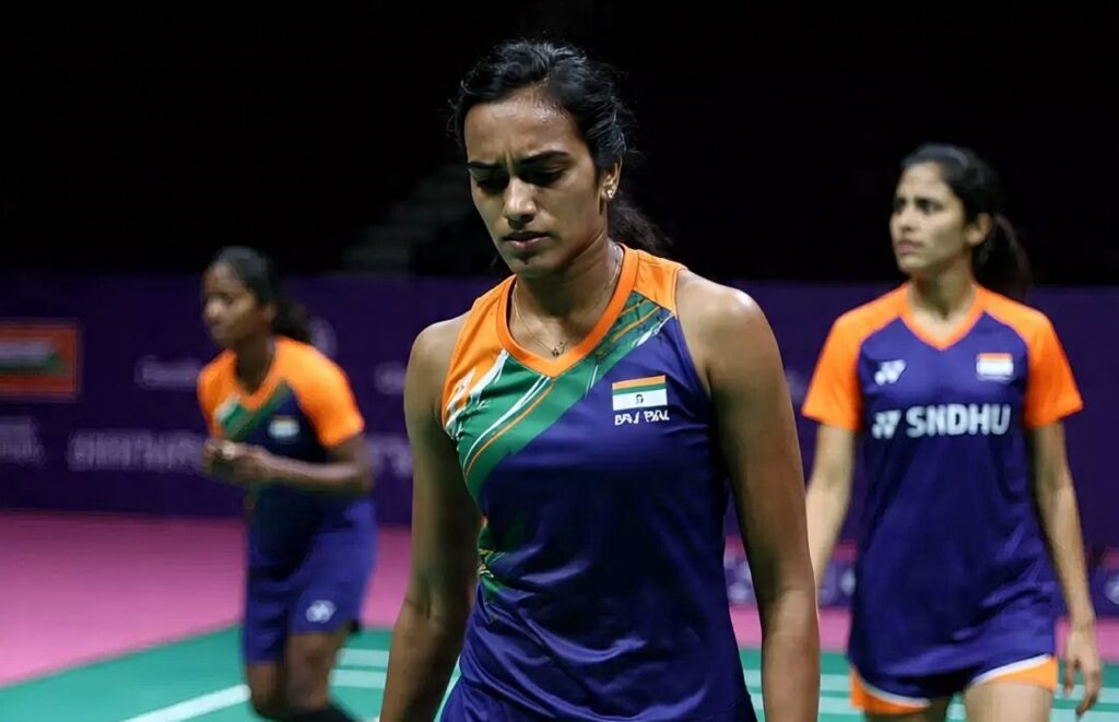 PV Sindhu in Indian jersey walking off court looking disappointed, followed by other Indian players like Lakshya Sen, Satwik-Chirag, and Anmol Upadhyaya, all showing visible frustration after crashing out of the Japan Open 2025.