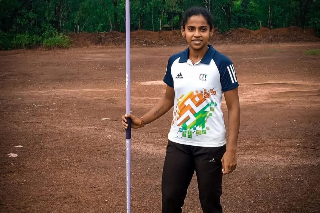 Indian athlete Karishma Sanil holding a javelin in pre-throw stance.