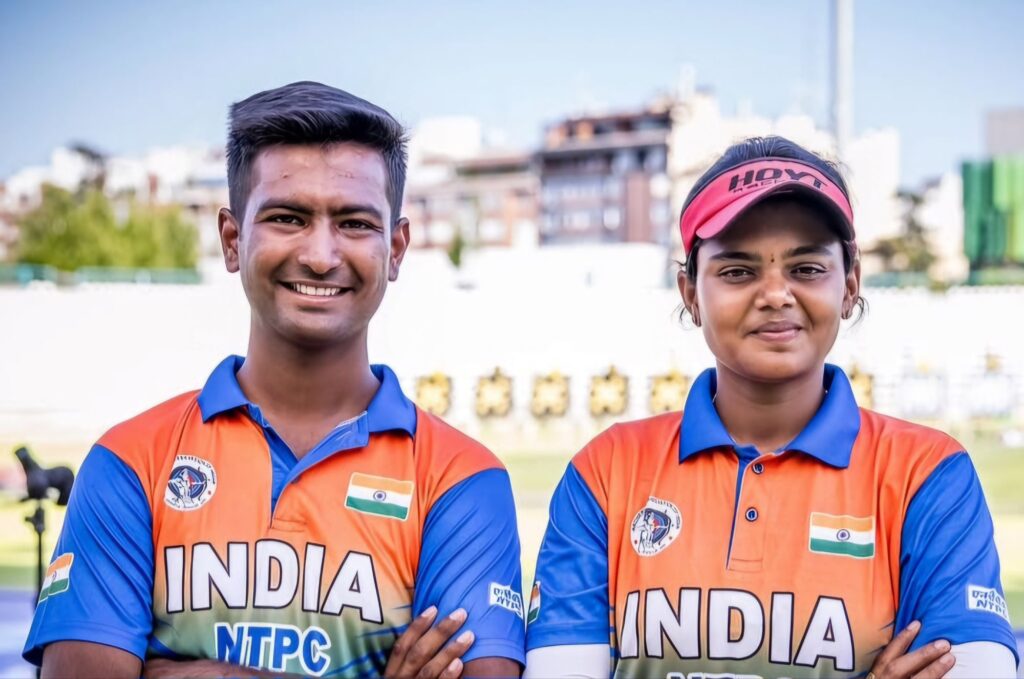 Rishabh Yadav and Jyothi Surekha Vennam smiling in Indian archery team jerseys after winning bronze at Archery World Cup Stage 4 in Madrid.